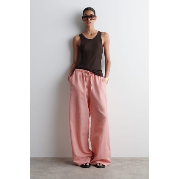 model wearing black top and pink Cos WIDE-LEG LINEN DRAWSTRING TROUSERS