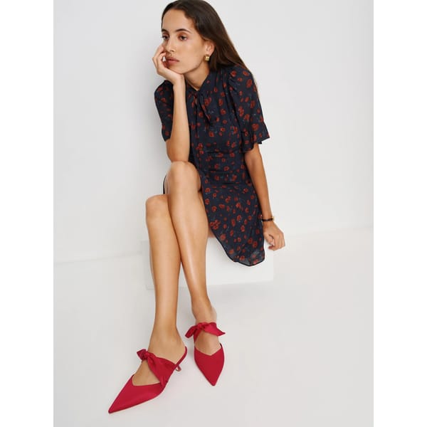 model wearing black dress and red Reformationo Milk Glass Heeled Mule by Reformation x Nara Smith