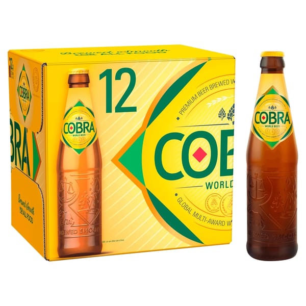 A 12-pack box of Cobra Premium Beer is shown with one bottle beside it. The yellow box features green and gold branding and images of the bottle, making it perfect for drinks pairing with crisps—ideal for food journalists seeking world beer experiences.
