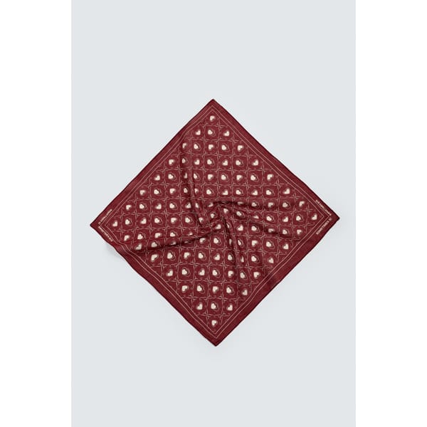 A maroon square scarf with a repeating white paisley pattern, laid flat against a light grey background—perfect for adding classic flair to your look. Discover style tips for men to wear it with confidence.