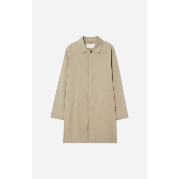 A beige, knee-length trench coat with long sleeves, a single front button, two slanted side pockets, and a classic collar—an essential piece for men’s fashion—displayed on a plain white background.