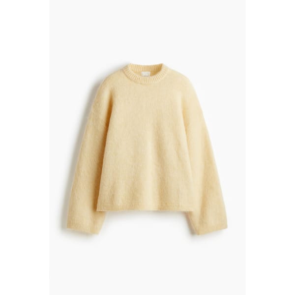 A cream-coloured, long-sleeve, fuzzy knit jumper from the H&M new season collection with a crew neckline, laid flat on a white background.