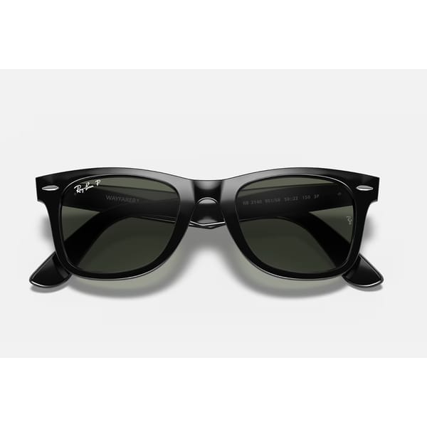 A pair of black Ray-Ban Wayfarer sunglasses with dark green lenses shown against a plain white background—an essential accessory in any list of style tips for men.
