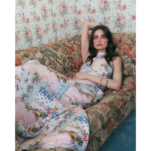 model laying on floral sofa wearing lforal prink blue sheer dress