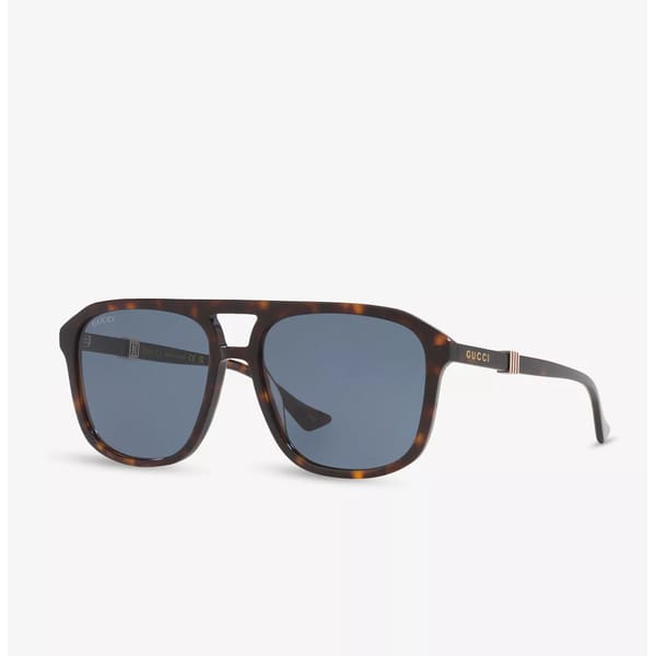 Tortoiseshell sunglasses with square blue lenses, a double bridge, and thin arms featuring gold accents and the Gucci logo on the sides, displayed on a white background.