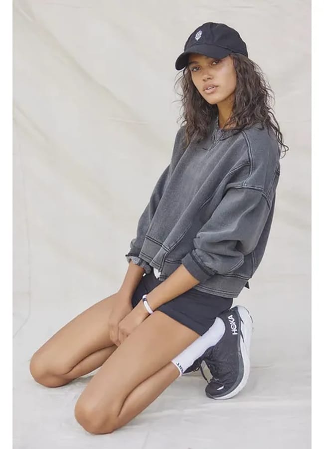 MODEL WEARS GREY SWEATSHIRT
