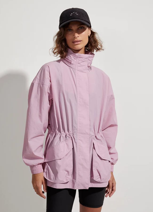 model wears pink windbreaker jacket