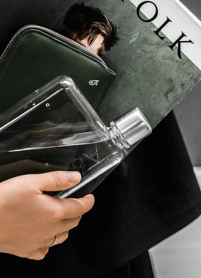 hand holding memo water bottle, files and magazines