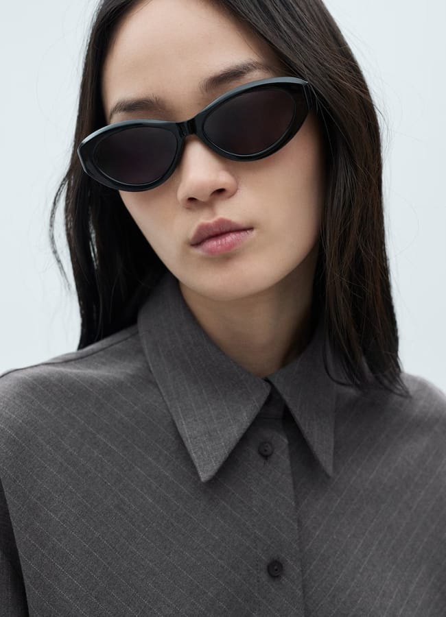 close up of model wearing collared shirt dress and black sunglasses