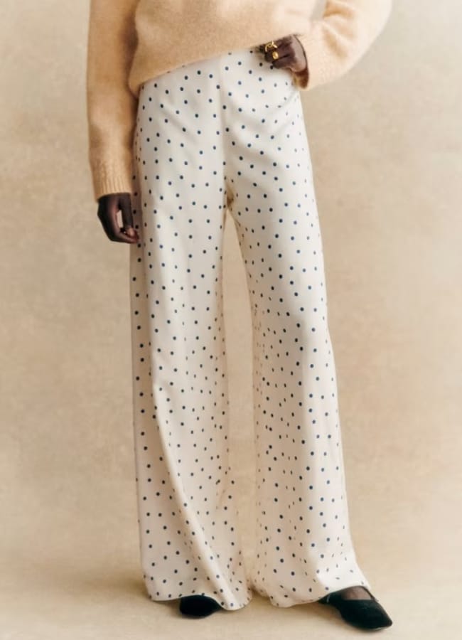 close up of model's legs in white and navy polka dot trousers