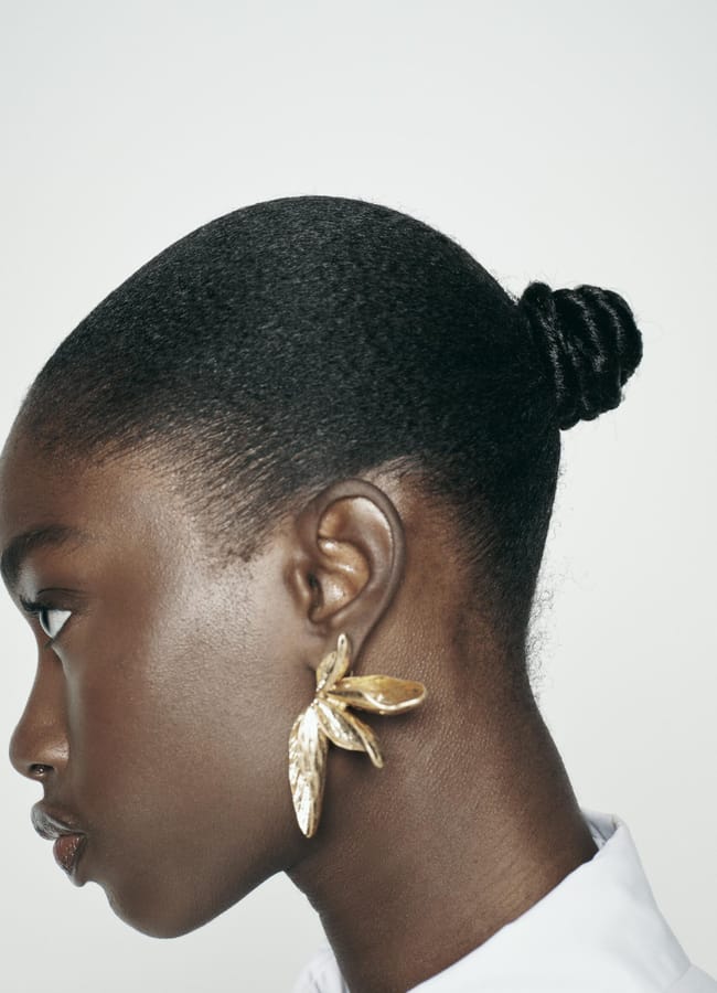 model wearing gold leaf earrings