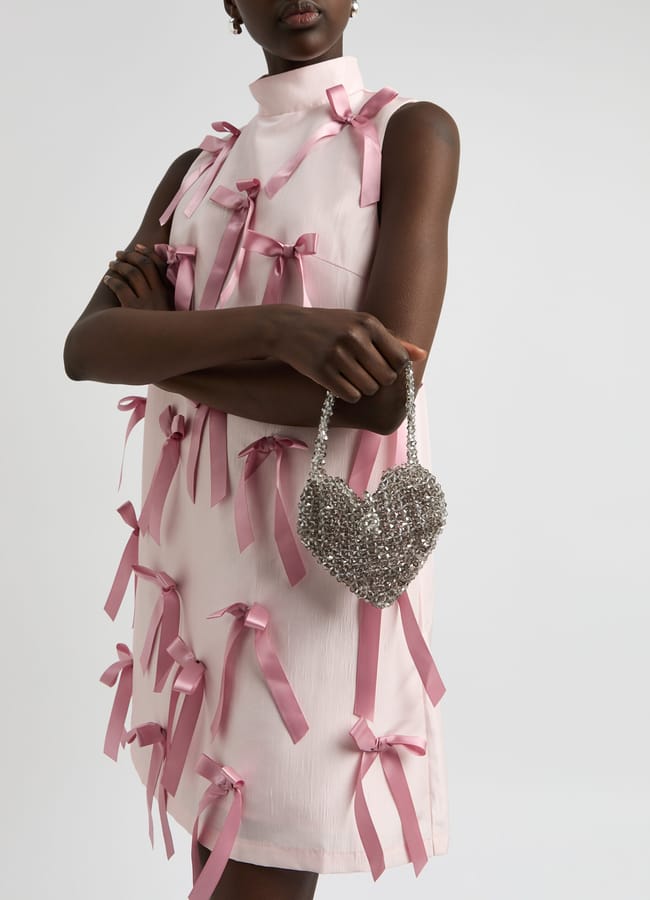 model in pink dress wearing SISTER JANE Black swan mini beaded heart top handle bag