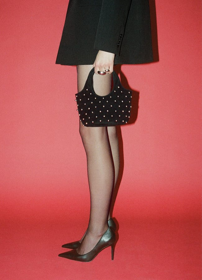 model holding MANOG Handbag with decorative studs