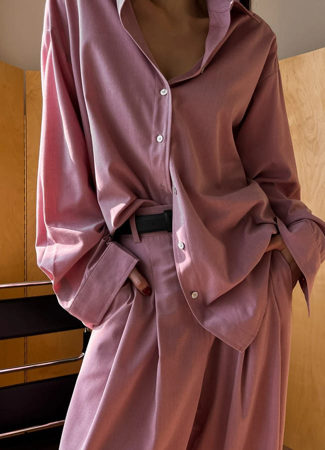 close up of model wearing pink shirt and trousers