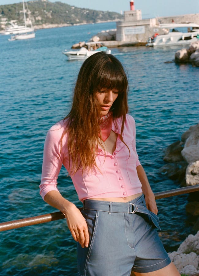 Model by sea wearing pink cardigan
