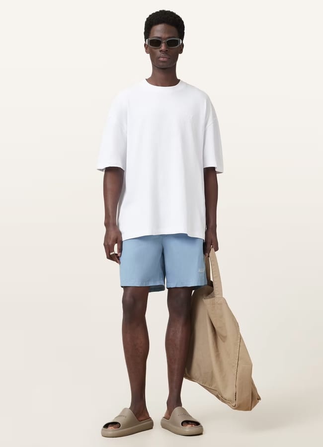 male model wearing white tshirt and AllSaints Underground Swim Shorts