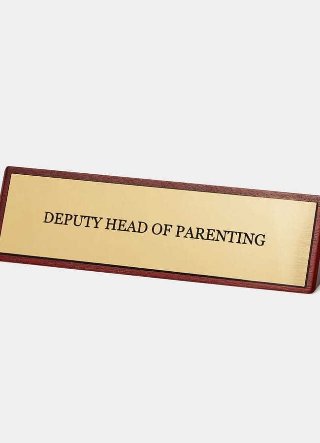 desk sign that says 'deputy head of parenting'