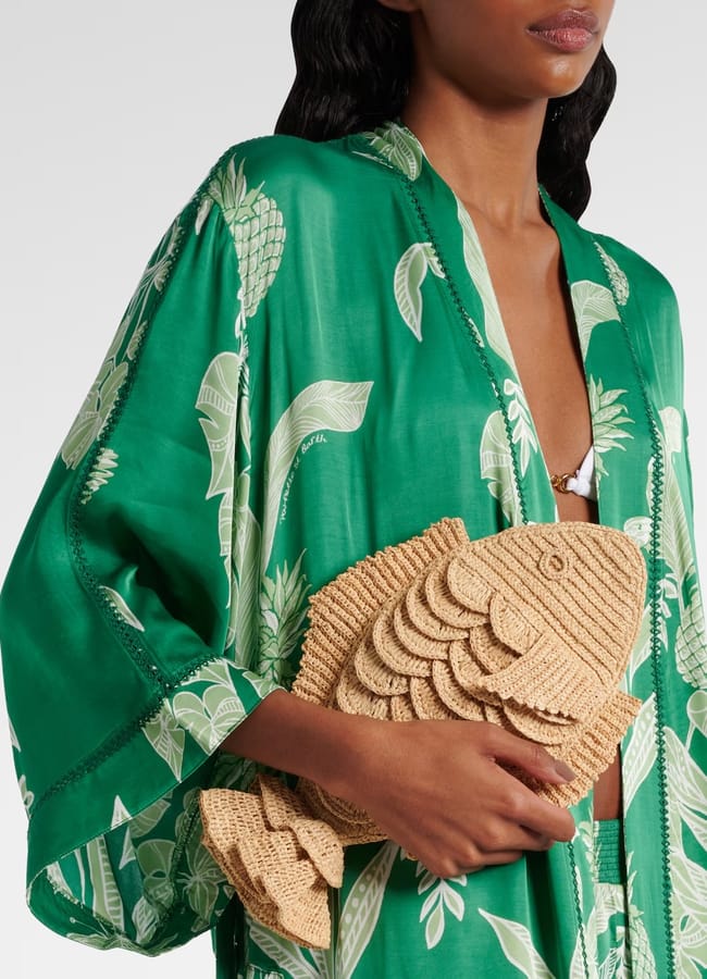 model wearing green dress holding fish raffia bag