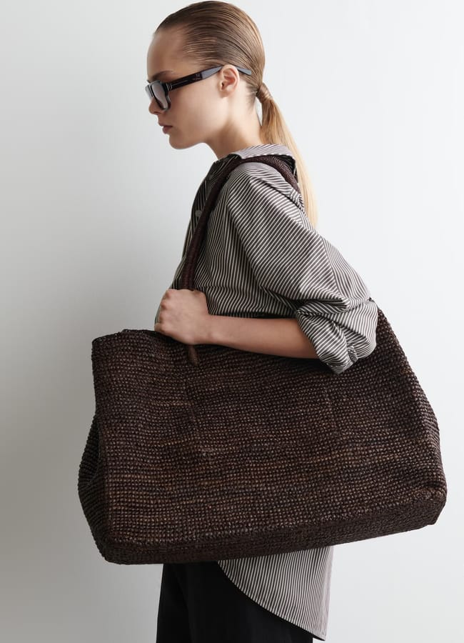 model wearing OVERSIZED HAND-WOVEN TOTE BAG - RAFFIA