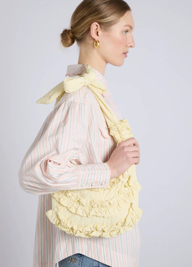 model holding DM quinn slouchy bag in butter yellow