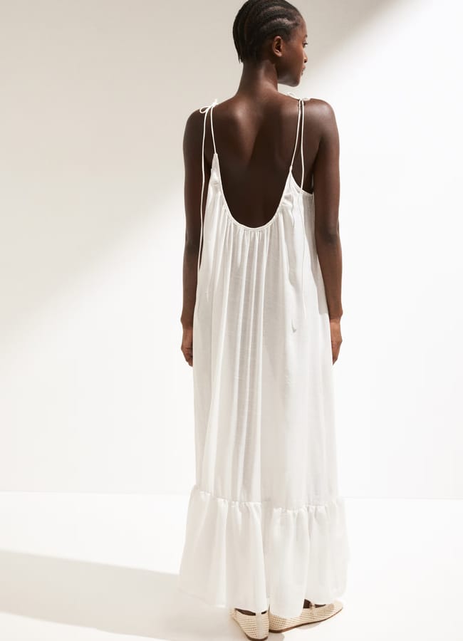 model from back wearing white maxi beach dress