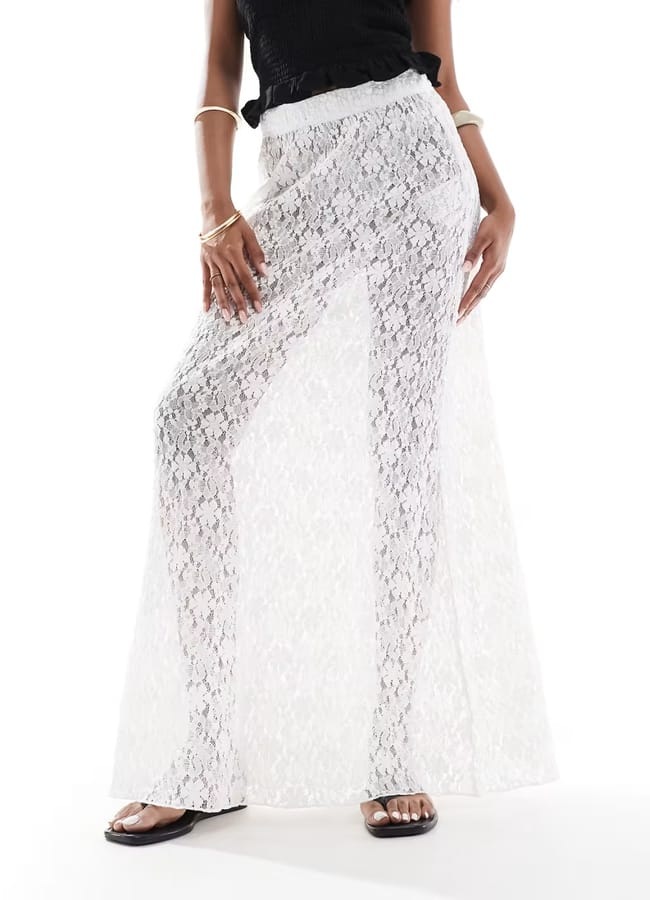 close up of model's legs wearing white lace maxi skirt