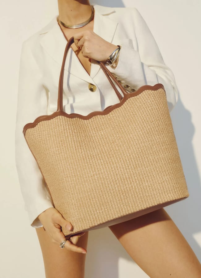 model close up holding Reformation Isabella Tote instraw with scalloped edge