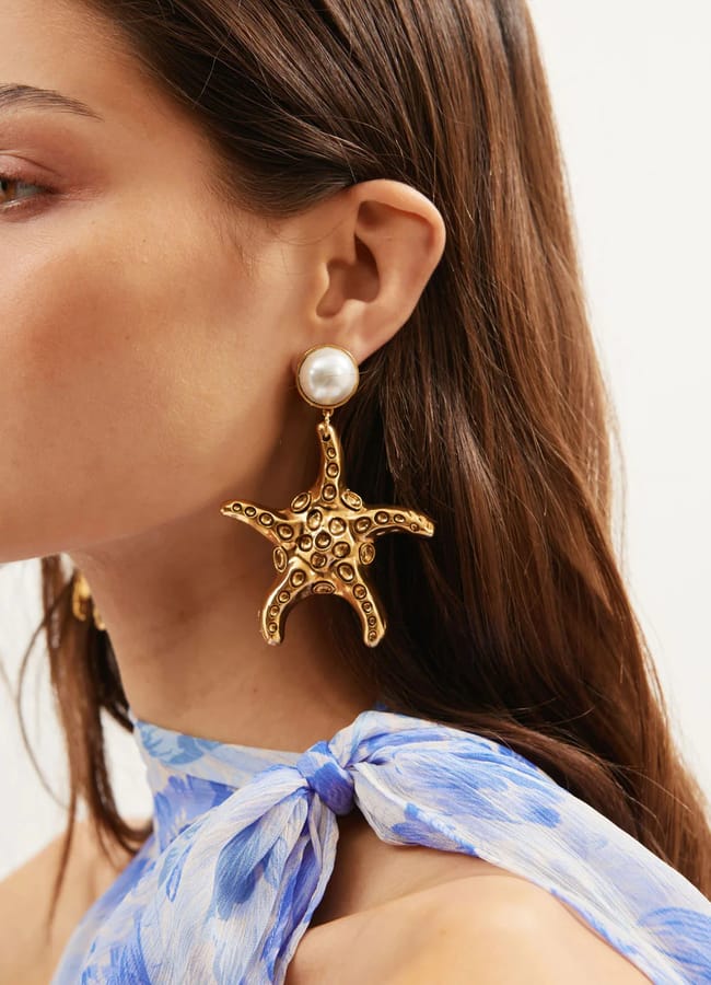 model wearin starfish and pearl shape Zeina Earrings £125 Exclusive to RIXO