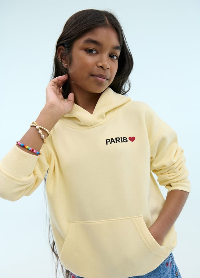 girl wearing yellow paris hoodie