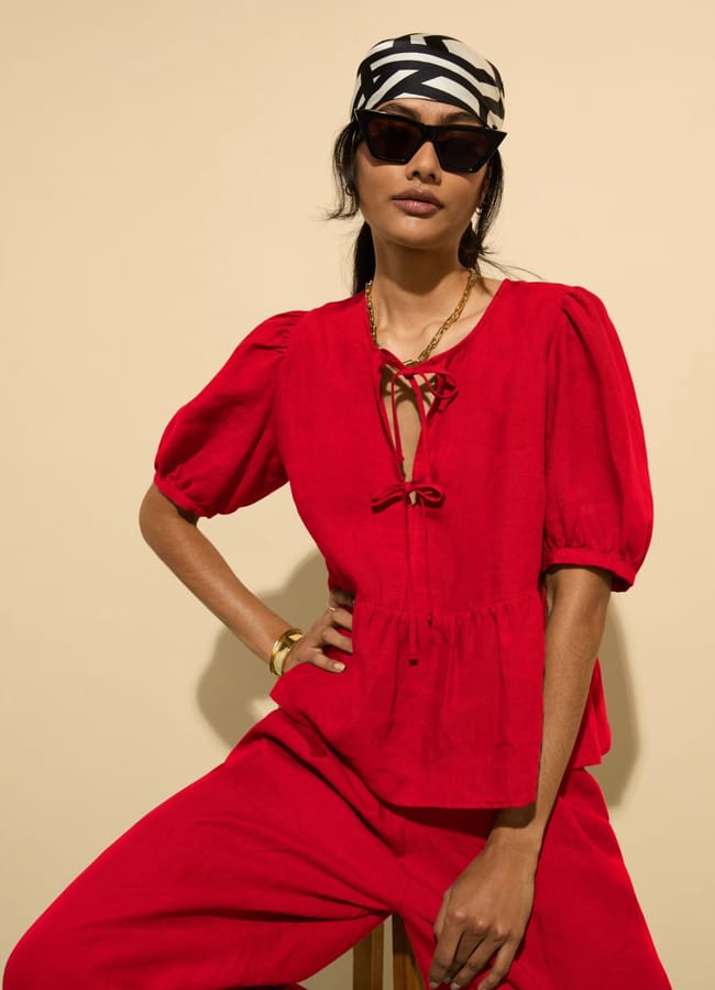 model wearing red Baukjen Pure Linen Tie Front Blouse and trousers