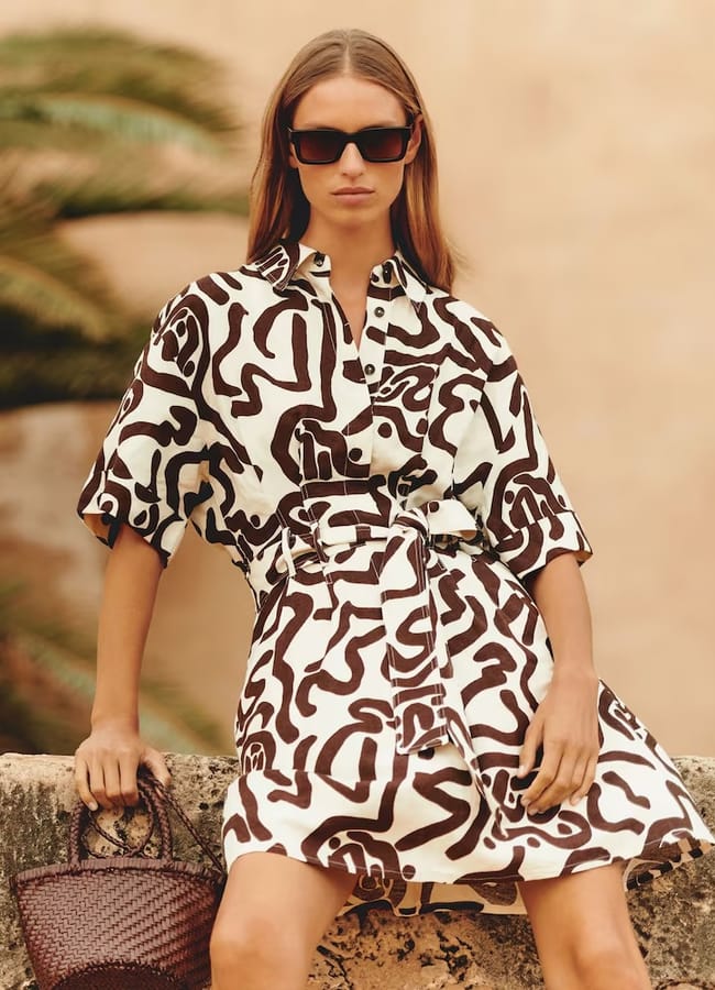 model sitting wearing Camelia Linen Blend Printed Shirt Dress in Brown/Ivory