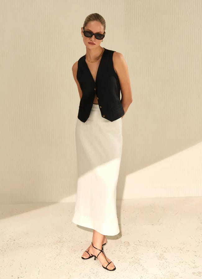 model wearing Como linen vest (black) and skirt in white