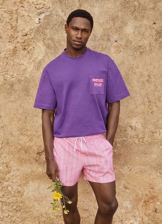 male model wearing purple t-shirt and pink shorts