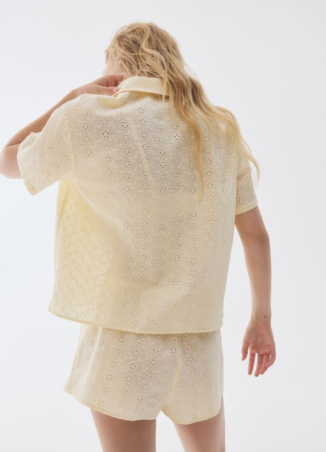 model from back wearing lemon yellow broderie anglaise short pyjama set
