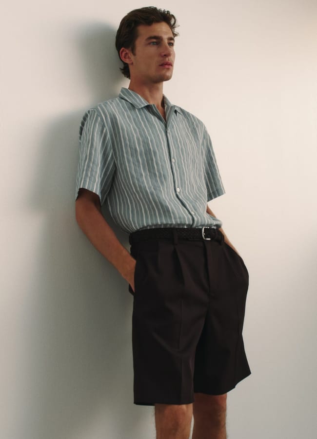 model wearing tailored shorts and blue shirt