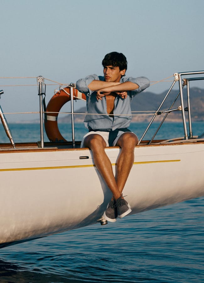 male model sitting on side of boat wearing Regular fit shirt with maltinto finish