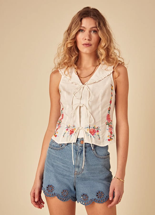 model wearing White Floral Embroidered Sleeveless Top and denim shorts