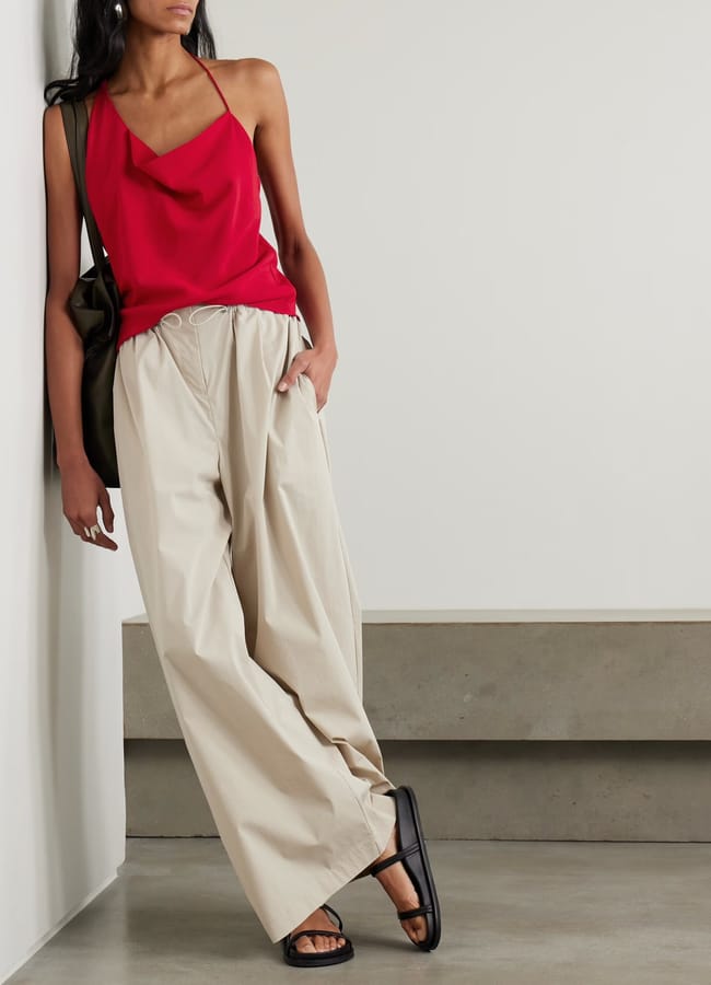 model wearing ST. AGNI Asymmetric draped satin top in red and cargo pants