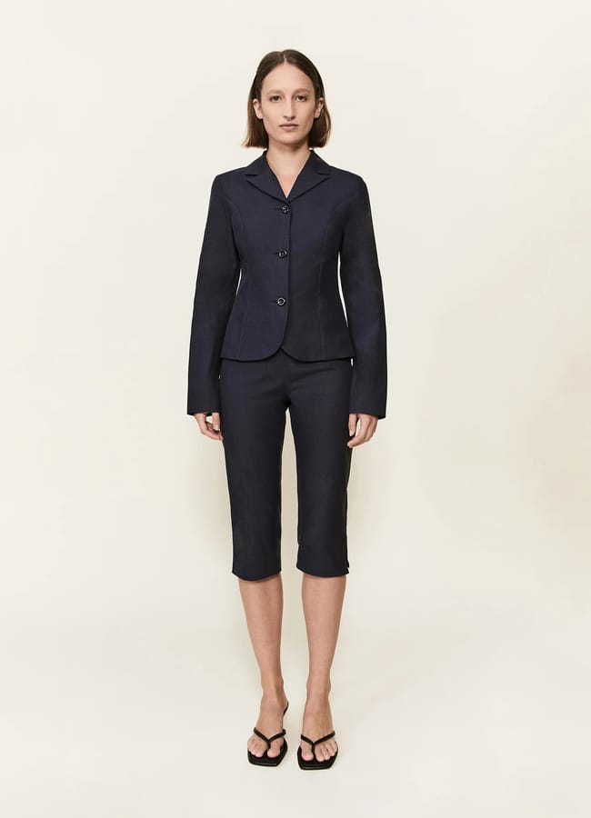 model wearing black The Alma Jacket and capri pants