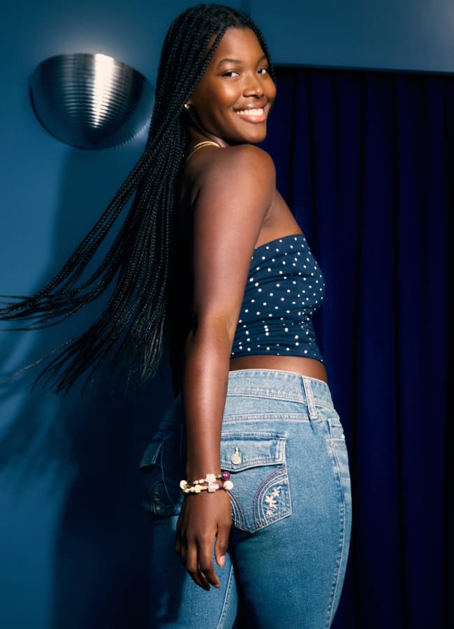 model wearing Low-Rise Medium Wash Embroidered Florals Boot Jeans