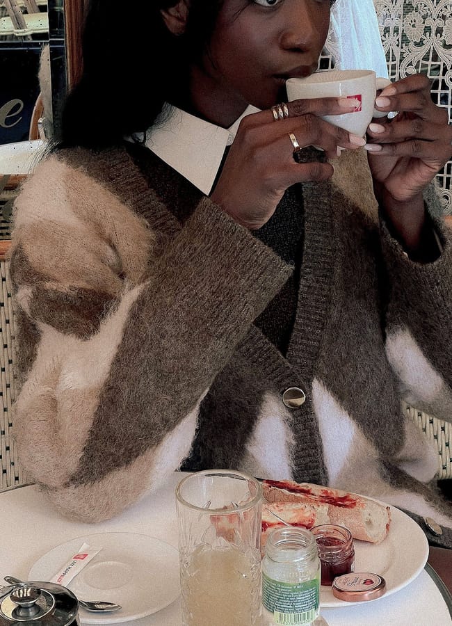 model sitting at cafe table wearing NA-KD Knitted Oversized Check Sweater