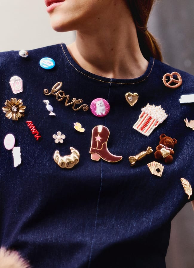 model close up wearing denim dress with brooches