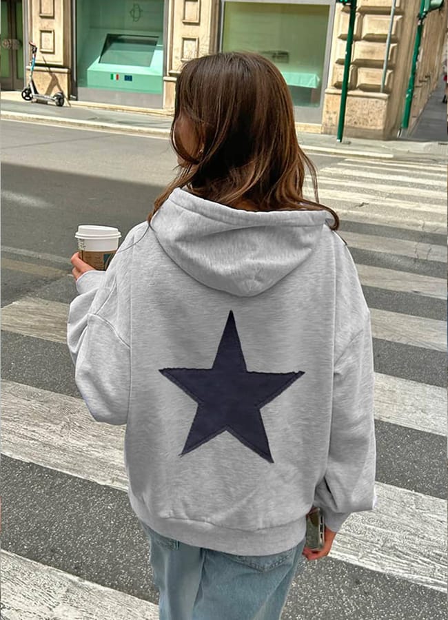 girl wearing grey hoodie with star print on back