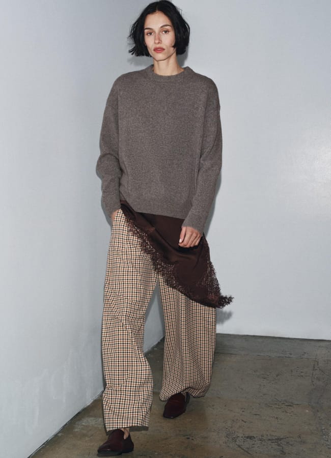 model wearing brown jumper and check trousers