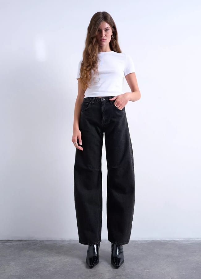 model wearing black barrel jeans