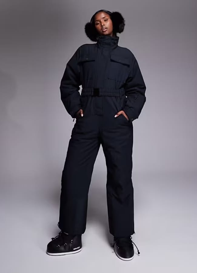 model wearing ASOS 4505 Ski retro belted ski suit with funnel neck in black