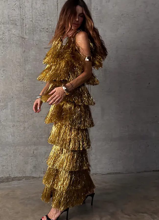 model wearing gold fringed dress