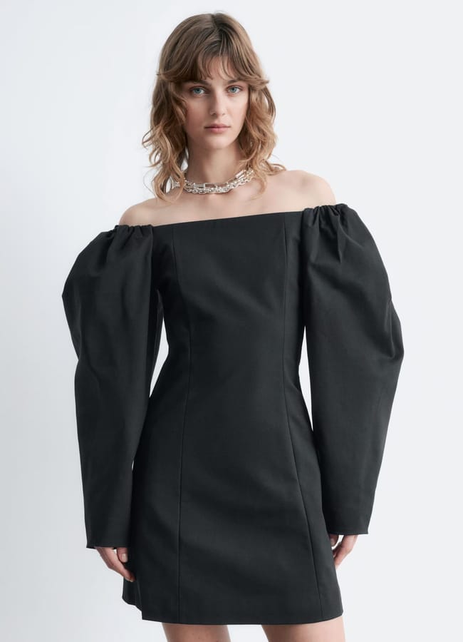 model wearing black Stories Off-Shoulder Mini Dress