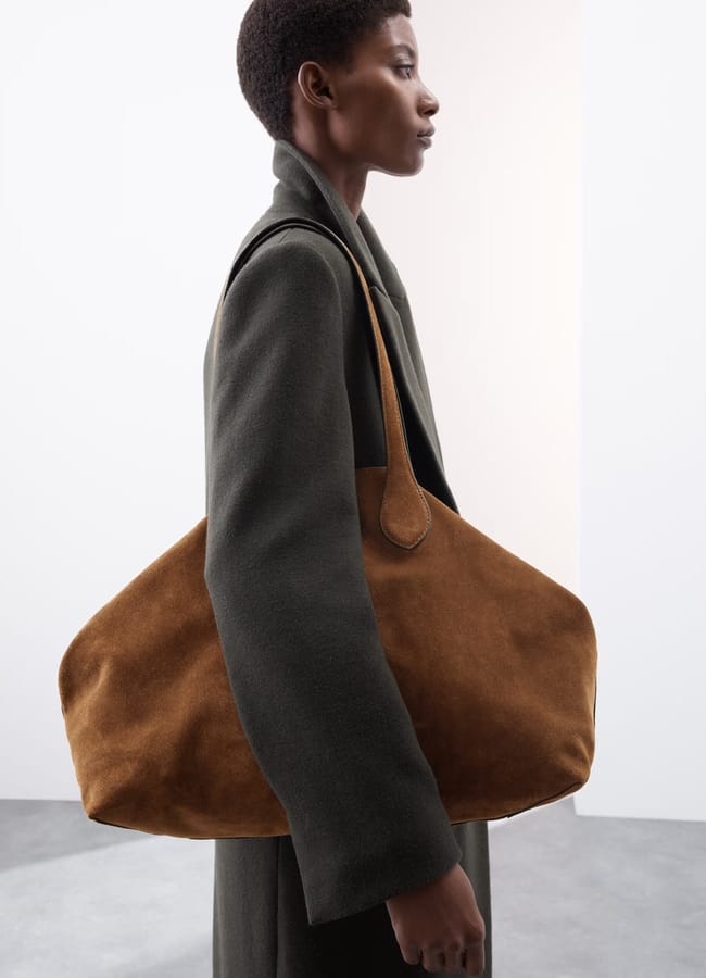 model carrying brown suede tote