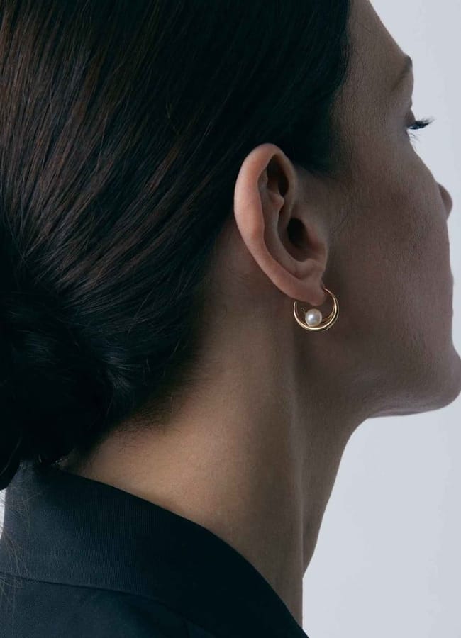 model from side wearing Toro Pearl Double Hoops